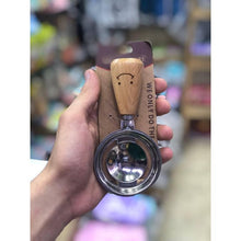 Load image into Gallery viewer, Hand holding a wooden and metal pet toy with packaging labeled 'WEONLY DO THE THING' in a store setting.