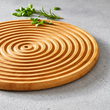 تحميل الصورة في عارض المعرض، Wooden cutting board with concentric circular pattern on a gray surface