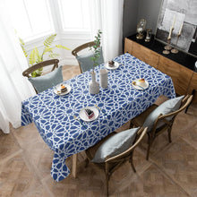 Load image into Gallery viewer, Dining table with a blue geometric patterned tablecloth in a well-lit room.