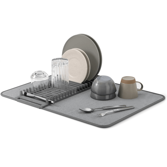 A gray dish drying mat with a rack, used to dry various kitchenware including plates, cups, and cutlery.