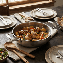 تحميل الصورة في عارض المعرض، Cooked chicken dish with vegetables in a pan on a table set for dinner.