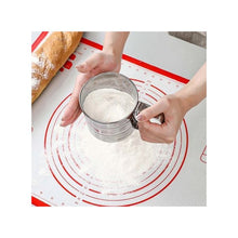 Load image into Gallery viewer, Manual stainless steel sieve being used to sift flour on a baking mat, showcasing its ease of use for baking.