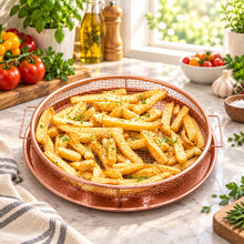 تحميل الصورة في عارض المعرض، Fried french fries in a wire basket on a wooden table with vegetables and kitchen items.