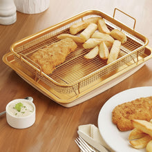 تحميل الصورة في عارض المعرض، Fried fish and chips on a wire rack over a tray with a side of tartar sauce on a wooden table.