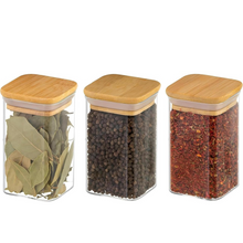Load image into Gallery viewer, Three glass jars with wooden lids containing different spices on a white background