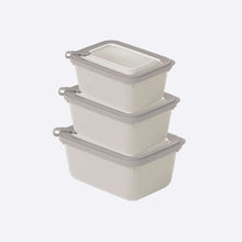 Load image into Gallery viewer, Set of three beige storage containers with gray lids on a white background