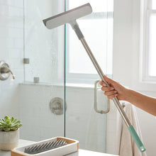 تحميل الصورة في عارض المعرض، A long-handled squeegee cleaning tool set laid out on a white cloth, including a metal extension pole, a squeegee head, a scrubber brush, and a mint green handle grip.
