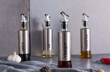 تحميل الصورة في عارض المعرض، Stylish stainless steel oil and vinegar dispenser set with glass bottles on kitchen counter.