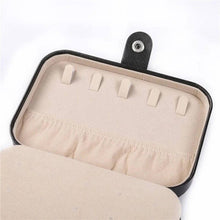 Load image into Gallery viewer, Interior view of a leather jewelry box showing hooks for necklaces and soft lining for protection.