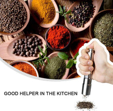 Load image into Gallery viewer, Stainless steel pepper and spice grinder in use, surrounded by various spices and herbs in bowls.