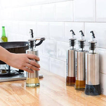 Load image into Gallery viewer, Olive oil dispenser and vinegar cruet set made of stainless steel and glass on a kitchen counter.