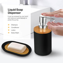 تحميل الصورة في عارض المعرض، Black and wooden liquid soap dispenser with a hand pressing it, next to a bar of soap on a tray.