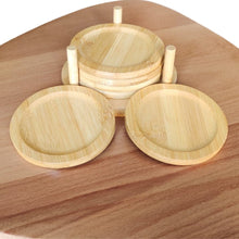 Load image into Gallery viewer, A set of bamboo coasters with a smooth finish, placed on a wooden surface, with a bamboo holder beneath them.