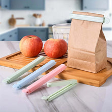 Load image into Gallery viewer, Set of silicone food wraps on a kitchen counter with apples and a paper bag.