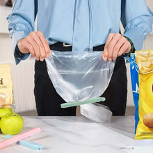 Load image into Gallery viewer, Person holding a clear plastic bag with snacks on a table