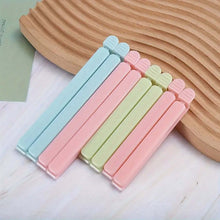 Load image into Gallery viewer, Set of pastel-colored plastic clips on a wooden surface