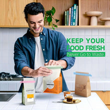 Load image into Gallery viewer, Man in a kitchen setting with food packaging, smiling and holding a bag.