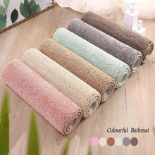 تحميل الصورة في عارض المعرض، Set of colorful bath mats on a wooden floor with a plant in the corner.