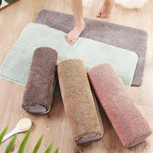 تحميل الصورة في عارض المعرض، Set of rolled-up bath mats in various colors on a wooden floor.