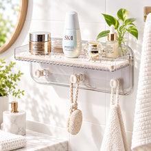 تحميل الصورة في عارض المعرض، A wall-mounted clear plastic bathroom organizer shelf with hooks and a textured tray holding skincare products, including SK-II and Lancère, against a white background.