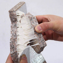 Load image into Gallery viewer, Person holding a block of granite with a white interior
