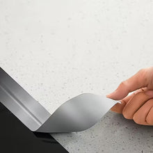 Load image into Gallery viewer, Hand applying a strip of adhesive tape to a surface