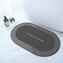 Load image into Gallery viewer, Gray bath mat with 'SHOWER ROOM' text on a bathroom floor.