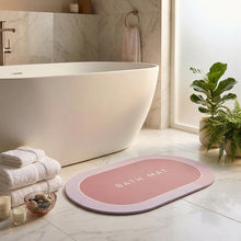 Load image into Gallery viewer, Pink oval bath mat printed BATH MAT on a bathroom floor