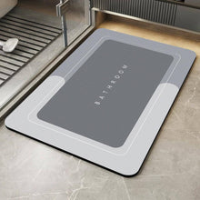 Load image into Gallery viewer, Gray bath mat with 'Bathroom' text on a tiled floor