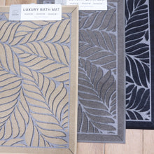 تحميل الصورة في عارض المعرض، Three bath mats with leaf patterns on a wooden floor, labeled 'Luxury Bath Mat' by KCC Promos.
