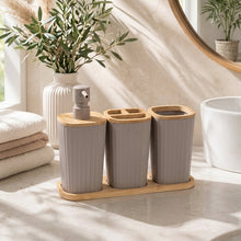 تحميل الصورة في عارض المعرض، A 3-piece bamboo bathroom set by Okyanus Home, featuring three ribbed gray ceramic containers with bamboo lids and a matching bamboo tray, displayed on a bathroom counter with soft natural light.