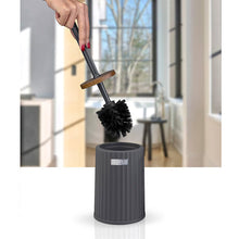 Load image into Gallery viewer, A toilet brush with a black bristle head and a gray handle is being lifted by a person's hand above a gray cylindrical holder, set against a blurred indoor bathroom background.