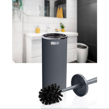 Load image into Gallery viewer, A dark gray cylindrical toilet brush holder with a matching toilet brush shown in front, with a blurred bathroom interior in the background.