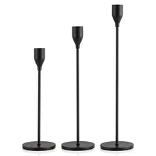 Load image into Gallery viewer, Three gold-finished metal candlesticks of graduated heights with circular bases, shown on a plain white background.