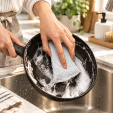 Load image into Gallery viewer, Hand using a white cloth to wipe a black surface with soapy water