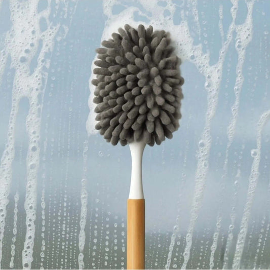 Cleaning brush with gray bristle head against a soapy water background
