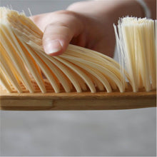 Load image into Gallery viewer, Close-up of a hand holding a dustpan brush with bamboo handle, featuring soft bristles for effective cleaning.