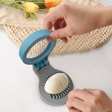 Load image into Gallery viewer, Hand using a kitchen tool to slice an onion on a white surface with tulips in the background