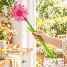 Load image into Gallery viewer, Hand holding a green fly swatter with a pink flower-shaped head on a white background