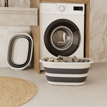 تحميل الصورة في عارض المعرض، Washing machine in a modern laundry room with a striped laundry basket and buckets.
