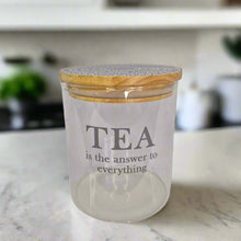 Load image into Gallery viewer, Glass jar with wooden lid on a kitchen counter, containing tea.