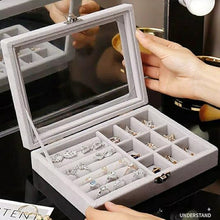Load image into Gallery viewer, Gray jewelry box with compartments filled with earrings, held by a hand.