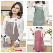 Load image into Gallery viewer, A person wearing a red and gray striped kitchen apron with a Mickey Mouse design standing in a kitchen.