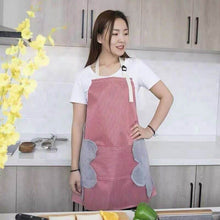 Load image into Gallery viewer, A person wearing a red and gray striped kitchen apron with a Mickey Mouse design standing in a kitchen.