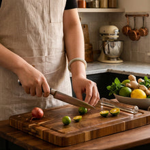 Load image into Gallery viewer, Person cutting limes on a wooden cutting board with a knife