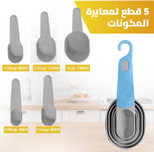 تحميل الصورة في عارض المعرض، Set of gray measuring spoons with blue handle on a kitchen counter, showing measurements.