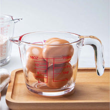 تحميل الصورة في عارض المعرض، Glass measuring cup with eggs on a wooden cutting board