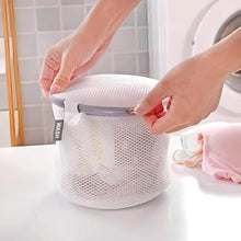 Load image into Gallery viewer, Hand closing a cylindrical mesh laundry bag