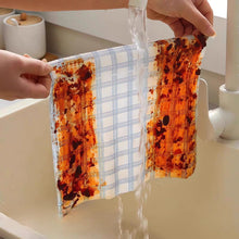 Load image into Gallery viewer, Hands holding a piece of fabric under running water in a sink.