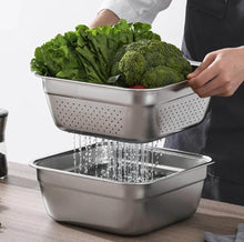 Load image into Gallery viewer, Stainless steel colander with vegetables being rinsed on a wooden surface.